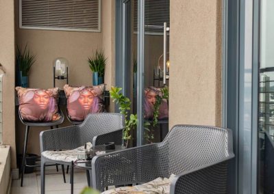 Private balcony at Menlyn Maine apartment with seating and decorative cushions