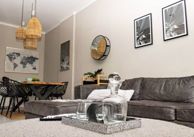 Modern Menlyn Maine apartment living area with sectional couch and dining table