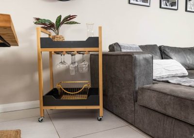 Compact mobile bar with glasses and wine rack inside Menlyn Maine apartment